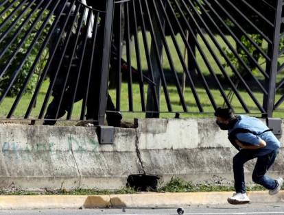 Un miembro de la Guardia venezolana apunta con un arma a través de la valla a David José Vallenilla, quien murió durante los enfrentamientos en una manifestación contra el gobierno del presidente venezolano, Nicolás Maduro, en Caracas, Venezuela, el pasado 22 de junio.
