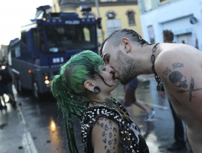 Una pareja se besa durante los enfrentamientos entre la policía alemana y los manifestantes contra la cumbre del G20 en Hamburgo, Alemania, el 6 de julio de 2017.