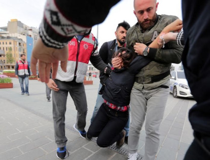 Agentes de policía vestidos de civil detienen a una manifestante mientras ella y otros se reúnen en la Plaza de Taksim para celebrar el Primero de Mayo y mostrar su descontento con el gobierno, en el centro de Estambul, Turquía, el primero de mayo de 2017.
