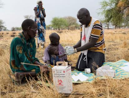 El promotor comunitario de salud, Gatbel, examina a un niño por paludismo en una clínica externa en Thaker, Sudán del Sur.