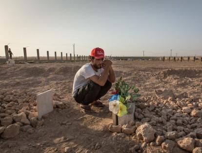 Ismael se sienta en la tumba de su primo y amigo, Hout, quien fue asesinado dos días antes durante la batalla por Raqqa, Siria.