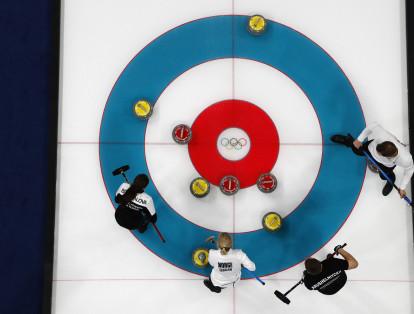 El curling consiste en arrojar una piedra de granito e intentar acercarla a las marcas que hay sobre el hielo. Mientras la piedra avanza, otro miembro del equipo prepara el camino con un cepillo.