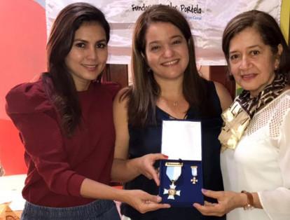 María Fernanda Portela (centro) creadora de la Fundación Carlos Portela, fue condecorada por la Asamblea Departamental del Valle del Cauca y recibió de manos de la diputada Mariluz Zuluaga (izquierda), el reconocimiento en grado Cruz de Caballero por los 20 años de labor social.