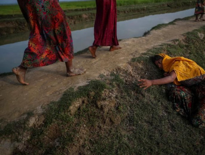 Una mujer  agotada que huye de la violencia en Myanmar pide ayuda a otros que cruzan hacia Palang Khali, cerca de Cox's Bazar, Bangladesh.