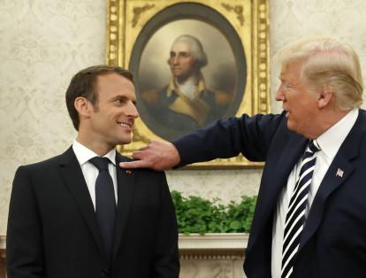 Inclusive en algún momento de la reunión, el presidente norteamericano Donald Trump, se dispuso a arreglar el vestido de su homólogo francés, Emmanel  Macron. En la imagen el presidente de Estados Unidos limpia los hombros del presidente de Francia.