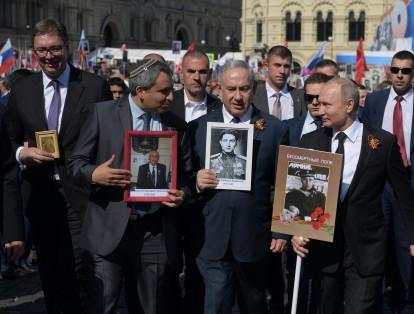 El primer ministro israelí, Benjamin Netanyahu (c.), el presidente serbio, Aleksandar Vucic (i.) y Putin participaron de la marcha con fotos de sus familiares.