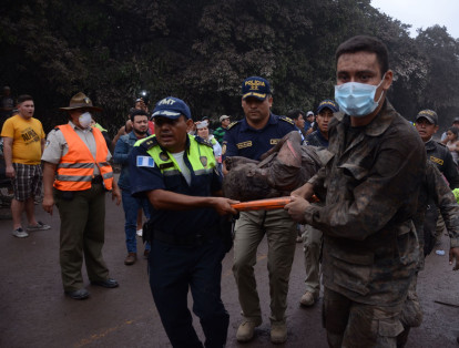 Un grupo de trabajadores de los equipos de rescate de Guatemala trasladan a un herido en El Rodeo, Escuintla, luego de la erupción del volcán de Fuego, que ha dejado al menos 25 muertos.