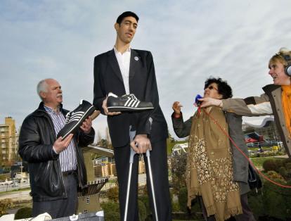 El sultán Kosen de Turquía, cuya altura alcanza los  2,46 metros recibe un par de tennis por parte de Georg Wessels (izquierda), un especialista en zapatos para personas de grandes tallas. Los hombres más altos del mundo se reunieron en París el 2 de junio de 2018.