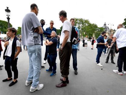 Los hombres más altos del mundo conversan con la gente que camina por la avenida Champs-Elysees en París durante su encuentro en la capital francesa.