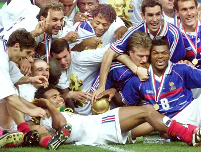 El equipo francés celebra luego de haber recibido el trofeo de la FIFA el 12 de julio en el estadio de Saint-Denis por haberse coronado campeones al ganarle a Brasil 3-0 en la Copa Mundo de Fútbol 
Francia 98.