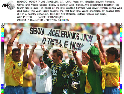 Los jugadores de la selección de fútbol de Brasil, levantan un cartel en el que se lee: Senna...Aceleramos juntos, el cuarto título en nuestro , el 17 de Julio, durante la celebración de la victoria en el Mundial 
USA 94.