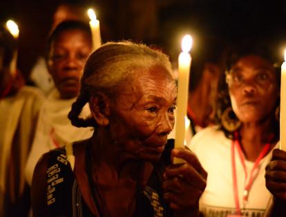 Una mujer mayor participa de una marcha con velas en el marco de las Fiesta de San Pacho que se lleva a cabo cada septiembre en Quibdó.