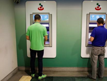 Los nuevos billetes fueron dispuestos en los cajeros automáticos de todo el país hacia la medianoche del domingo y la madrugada del lunes. En la foto, dos ciudadanos haciendo transacciones este lunes en Caracas.