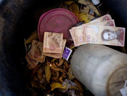 En esta foto se ve un fajo de billetes de 100 bolívares tirado a la basura.
