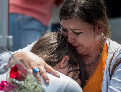 Mujer llora mientras abraza a su hija en el tributo de las víctimas del Colegio Rébsamen donde murieron 19 niños. La joven asistía a la institución.