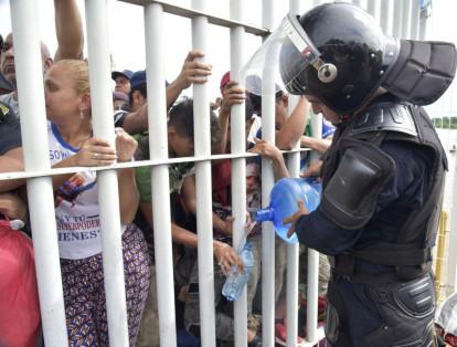 Miles de migrantes hondureños aguardan en el puente que une las dos naciones después de que <b>lograron librar la valla en la frontera con Guatemala para ingresar a México</b>, en el margen del Río Suchiate.