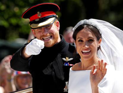 El Príncipe Harry y su esposa Meghan saludan mientras viajan en un carruaje tirado por caballos después de su ceremonia de boda en la Capilla de San Jorge en el Castillo de Windsor, que se realizó el 19 de mayo.