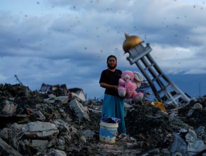 El 7 de octubre una mujer es fotografiada en Indonesia mientras sostiene un conejo de peluche. Segundos antes había encontrado los escombros de su casa, que fue destruida durante un terremoto.
