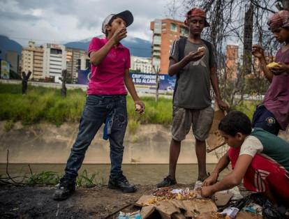 Un grupo de niños busca comida entre bolsas de basura que obtuvieron en una panadería de Caracas, capital de Venezuela.