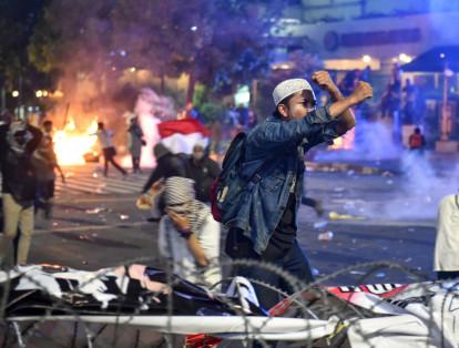 Manifestantes indonesios se enfrentan a la policía durante protestas contra el reelecto presidente del país, Joko Widodo, en Yakarta.