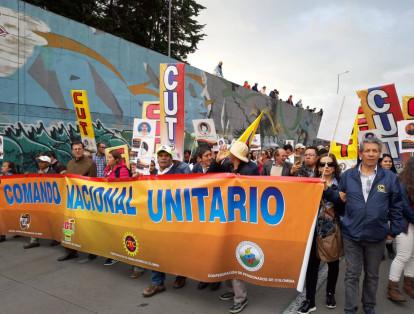 En Bogotá los movimientos obreros portan rostros que recuerdan a los líderes sindicales y sindicalistas asesinados en el país. Adelante de ellos marcha un grupo de la Consultiria para los Derechos Humanos y el Desplazamiento, Codhes. Portan banderas blancas.