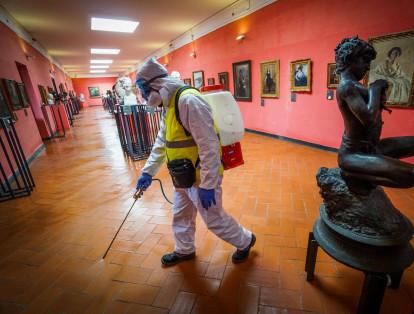 Personal especializado con equipo de protección desinfecta las habitaciones y piezas de arte del castillo Maschio Angioino en Nápoles, sur de Italia.