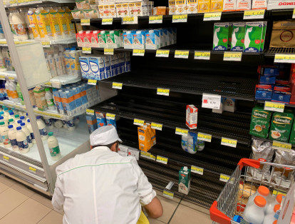 Un hombre repone los productos agotados en el supermercado en Roma este martes durante las medidas para contener el coronavirus. Cientos de personas acudieron angustiados a los supermercados para blindarse ante las nuevas restricciones.