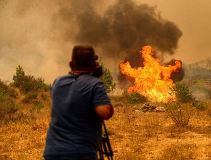 Un camarógrafo filma durante un incendio forestal masivo que envolvió una región turística mediterránea en la costa sur de Turquía cerca de la ciudad de Manavgat, el 29 de julio de 2021.