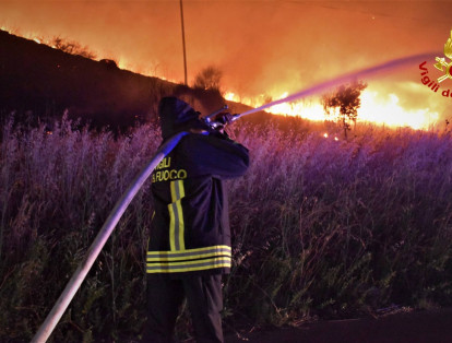Bomberos de Italia tratan de extinguir un incendio forestal en la isla de Sicilia, sur de Italia.