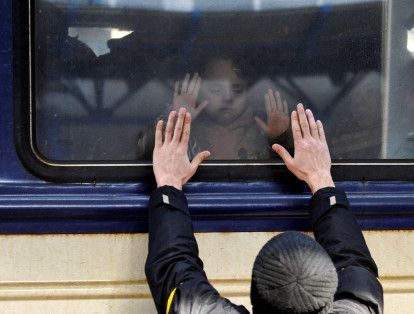 Un hombre coloca sus manos frente a la ventana del tren mientras que se despide de su hija, en la estación central de trenes de Kiev. Ucrania acusó al Kremlin de "terror nuclear" después de que la planta de energía atómica más grande de Europa fuera atacada y tomada por fuerzas invasoras.