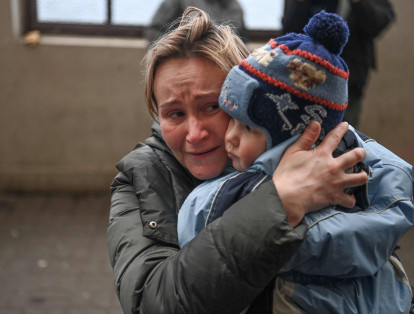 Una mujer sostiene a su hijo mientras intenta abordar un tren gratuito a Polonia en la estación de tren en Lviv, Ucrania occidental. Las fuerzas rusas tomaron la ciudad ucraniana de Kherson, el primer gran centro urbano en caer desde que Moscú invadió hace una semana.
