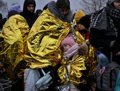 Con temperaturas bajas, las personas esperan para ser trasladadas, después de cruzar las fronteras de Ucrania hacia Polonia, en el cruce fronterizo de Medyka.