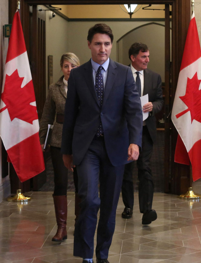 El primer ministro canadiense Justin Trudeau (centro), junto con la ministra de Asuntos Exteriores Mélanie Joly (izq.) y el ministro de Seguridad Pública, Dominic LeBlanc, llegan a una conferencia de prensa el 14 de octubre de 2024.