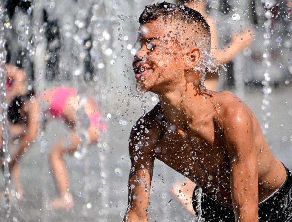 Un niño se refresca en una fuente del centro de Duisburg (Alemania).