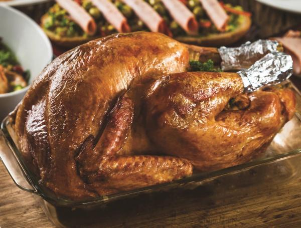 La imagen clásica de un pavo al horno o a la brasa en  una mesa de celebración.