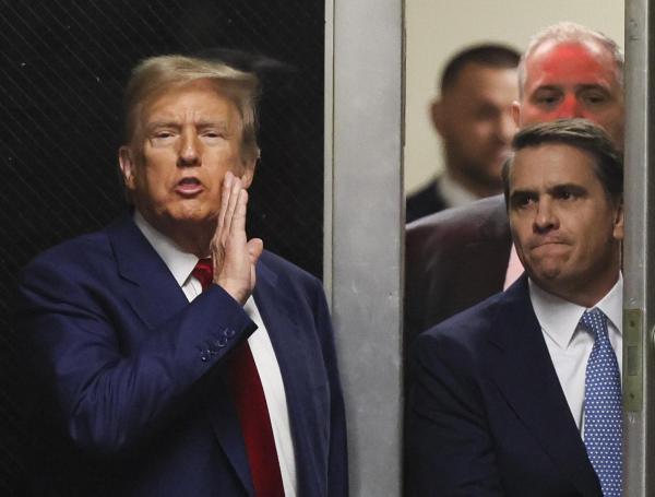El expresidente de Estados Unidos Donald Trump habla hacia la prensa en un pasillo fuera de la sala del tribunal.