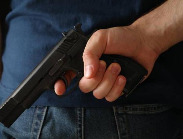A man hold a gun from behind. Self defense weapo
