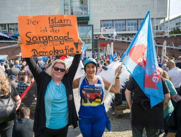 Una partidaria del partido de extrema derecha AfD sostiene un cartel que dice "El Islam es el clavo en el ataúd de la democracia".