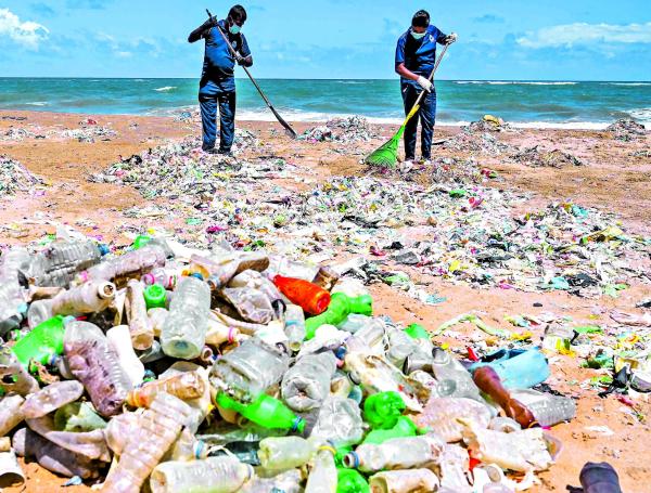 Policía ambiental intenta limpiar basuras en Mount Lavinia, Colombo, Sri-Lanka.