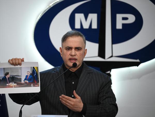 El fiscal general de Venezuela, Tarek William Saab, muestra una imagen de su reunión con el abogado del opositor Edmundo González.