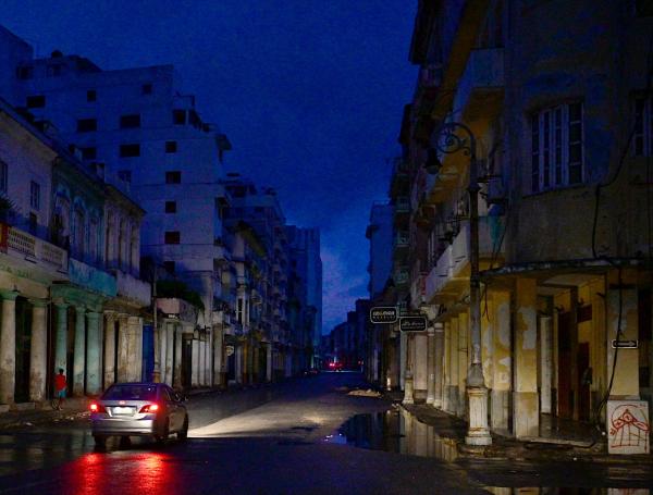Un coche circula por una calle durante un apagón nacional causado por un fallo de la red eléctrica en La Habana.