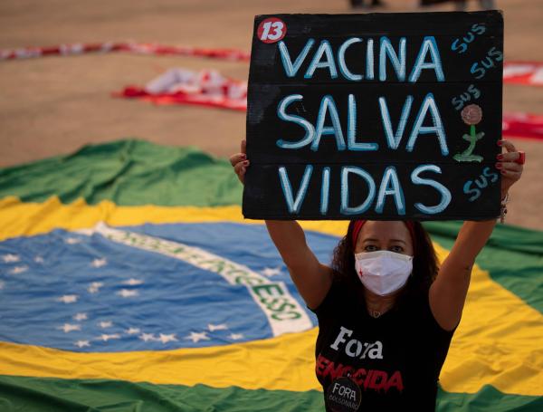 Una mujer sostiene un cartel que dice "las vacunas salvan vidas" durante una protesta contra la dictadura militar y el gobierno del presidente de Brasil Jair Bolsonaro.