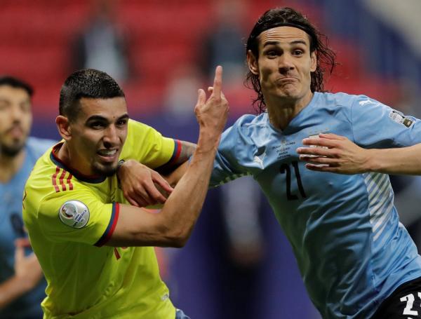Muñoz y Cavani  luchan por la pelota.
