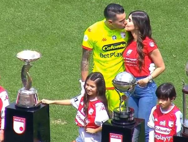 Leandro Castellanos besa a su esposa y posa junto a los trofeos que ganó con Santa Fe.