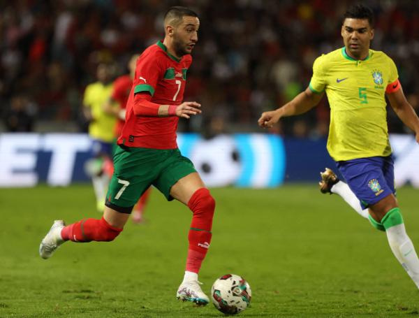 Casemiro (der.) marca a Hakim Ziyech.