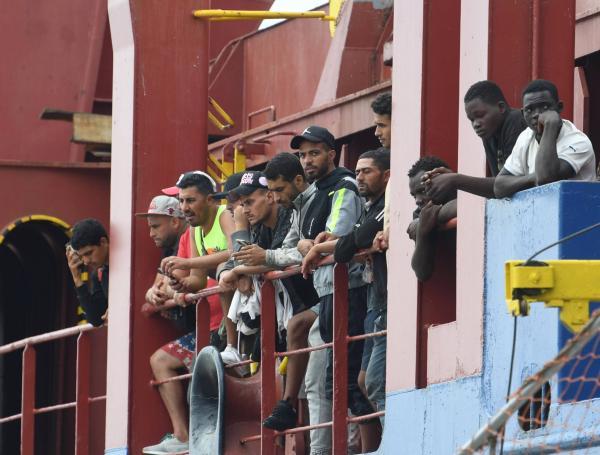 Un grupo de migrantes, varios provenientes de Túnez, espera para desembarcar en el puerto de Salerno, Italia.