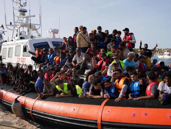 Migrantes llegan en pequeñas embarcaciones al puerto de Lampedusa, en Italia.