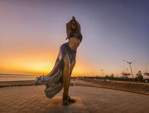 Turistas y locales cruzan la reja impuesta por las autoridades para tomarse fotos más cercanas a la estatua de Shakira en el Gran Malecón del Río, la cual estará habilitada al púbico de manera oficial en el mes de marzo al terminar las obras del espacio público aledañas a la estatua.