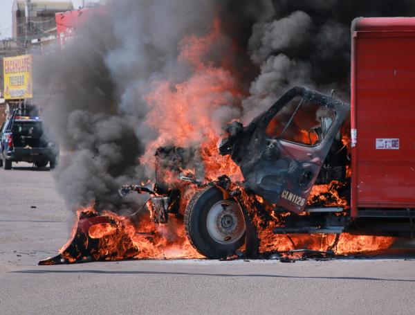 A truck on fire is seen on the streets of Culiacan, Sinaloa State, Mexico, on September 11, 2024. Elements of Mexico's National Guard were deployed in the state of Sinaloa, in the northwest of the country, amid an escalation of violence that authorities attribute to internal struggles within the Sinaloa cartel following the capture of its leader, Ismael "Mayo" Zambada. (Photo by Ivan MEDINA / AFP)