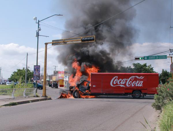 A truck on fire is seen on the streets of Culiacan, Sinaloa State, Mexico, on September 11, 2024. Elements of Mexico's National Guard were deployed in the state of Sinaloa, in the northwest of the country, amid an escalation of violence that authorities attribute to internal struggles within the Sinaloa cartel following the capture of its leader, Ismael "Mayo" Zambada. (Photo by Ivan MEDINA / AFP)